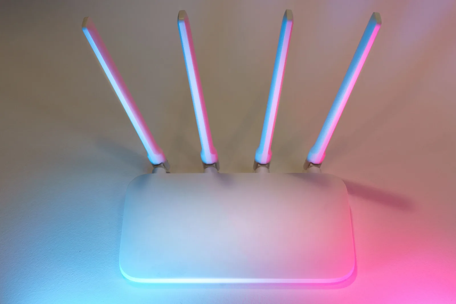 Home Wi-Fi router with four antennas lit in blue and pink